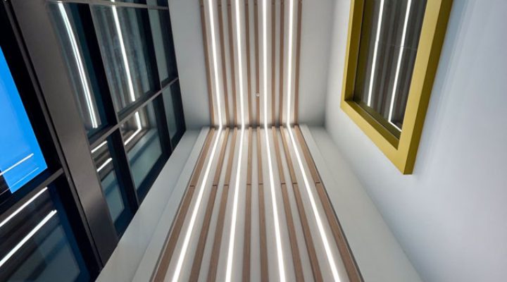 Vertical image showcasing a high-end interior with artistic linear lighting installations that enhance the architectural beauty of the space.